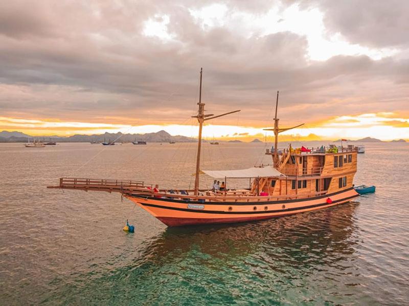 un barco sentado en el agua con un muelle en Trip Labuanbajo 3D2N departure every Friday en Labuan Bajo