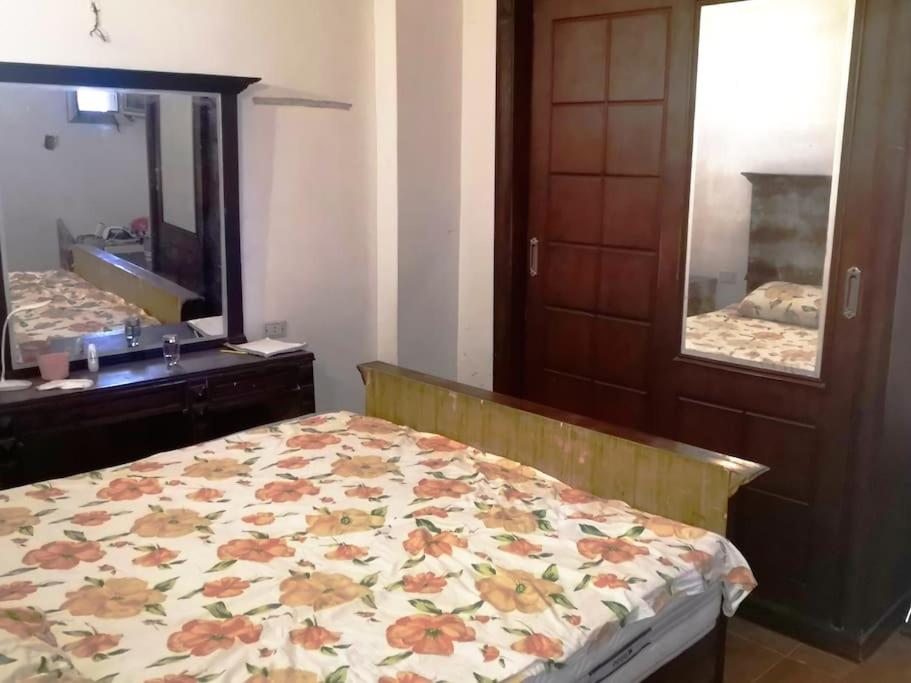 een slaapkamer met een bed, een dressoir en een spiegel bij Cozy 15 min to airport 10 to public transport in Caïro