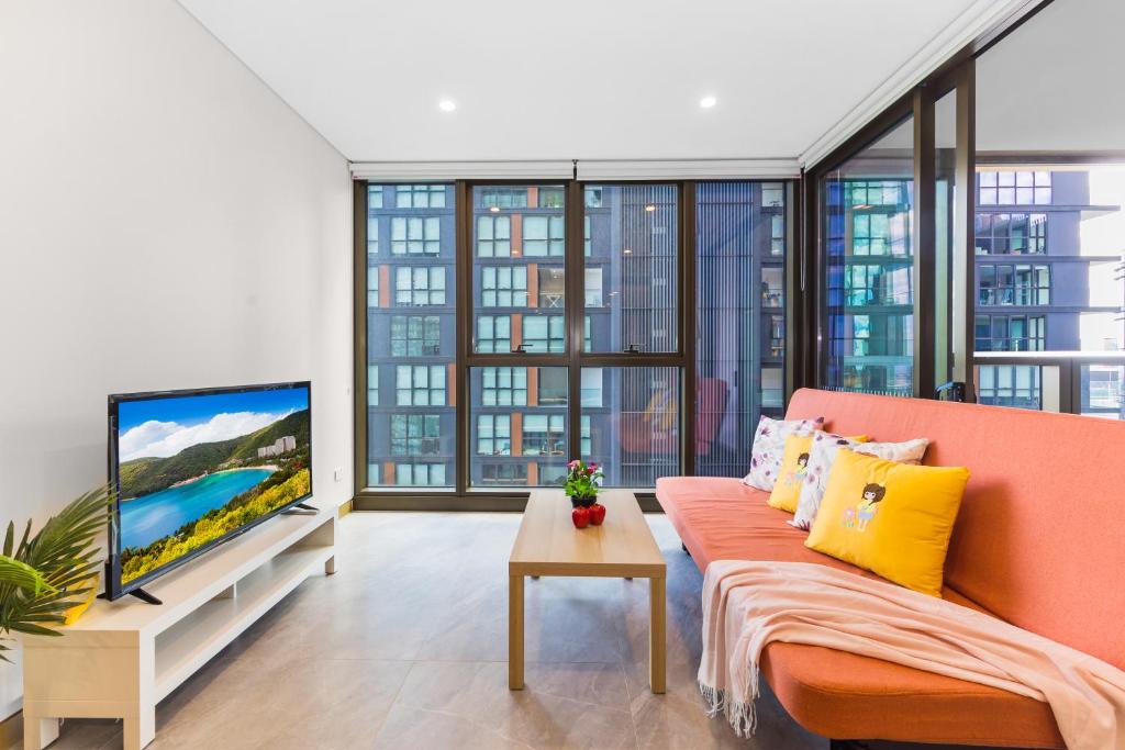 a living room with a couch and a flat screen tv at 1Br Apt by Train&Shopping Pool&Gym with Water View in Sydney
