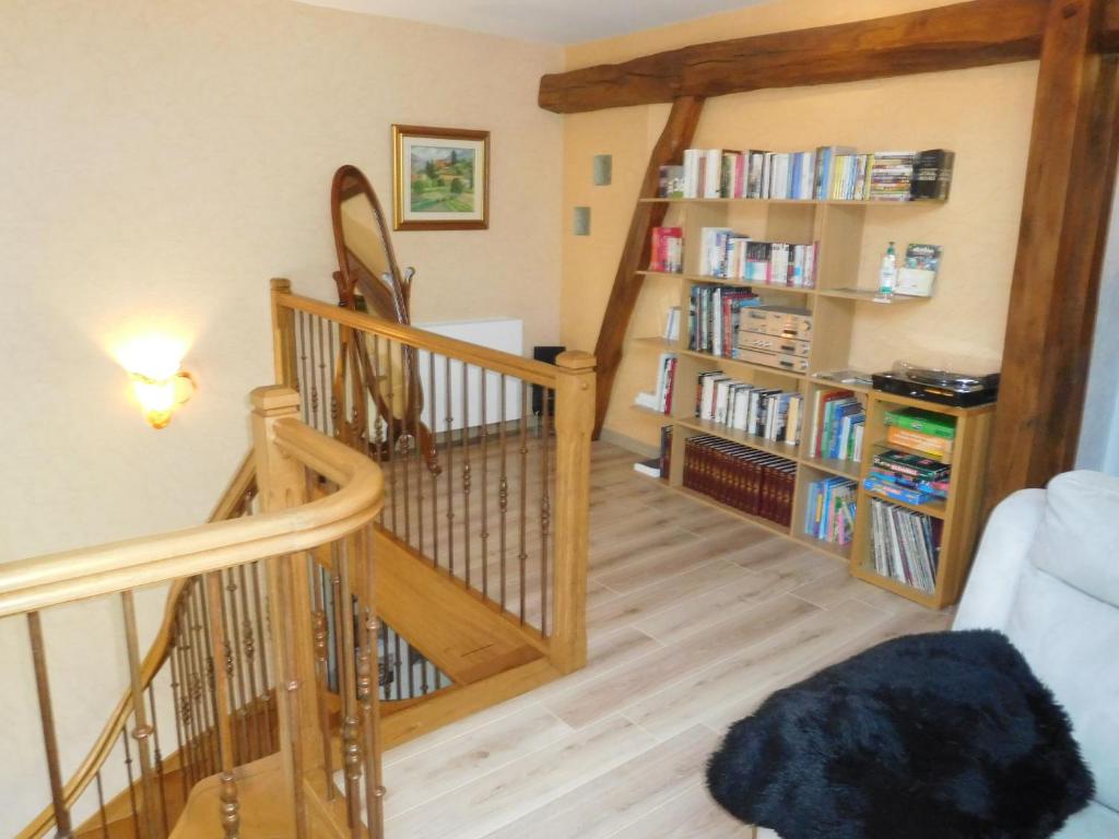 a living room with a staircase and a book shelf with books at Guestroom Arbigny-sous-Varennes, 2 pièces, 4 personnes - FR-1-611-72 