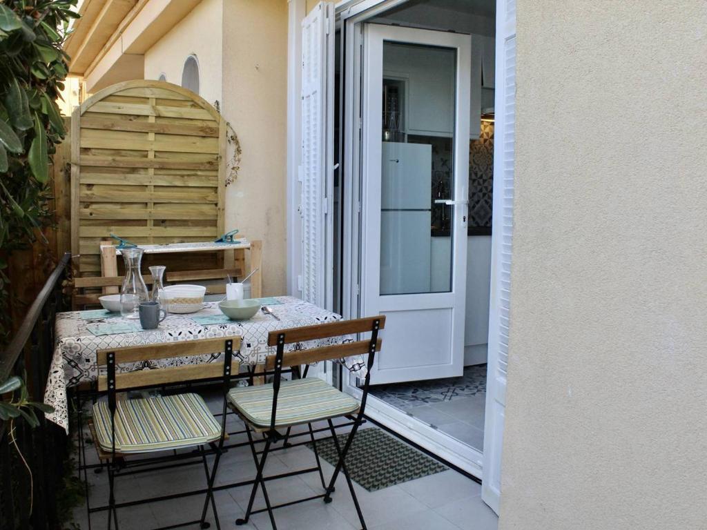d'une terrasse avec une table, des chaises et un réfrigérateur. dans l'établissement Charmant 2P Climatisé, Terrasse et Parking, 4 Couchages - Villeneuve-Loubet - FR-1-252A-115, à Villeneuve-Loubet