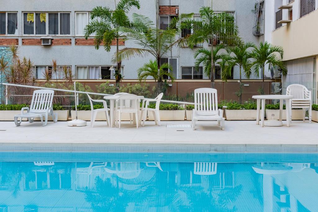 um pátio com cadeiras e uma piscina em Flat Posto 6 com Piscina - Copacabana no Rio de Janeiro