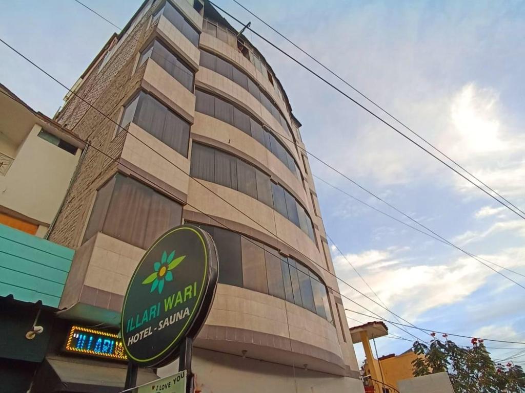 un edificio con una señal delante de él en Illari Wari l - Hotel Sauna, en Ayacucho