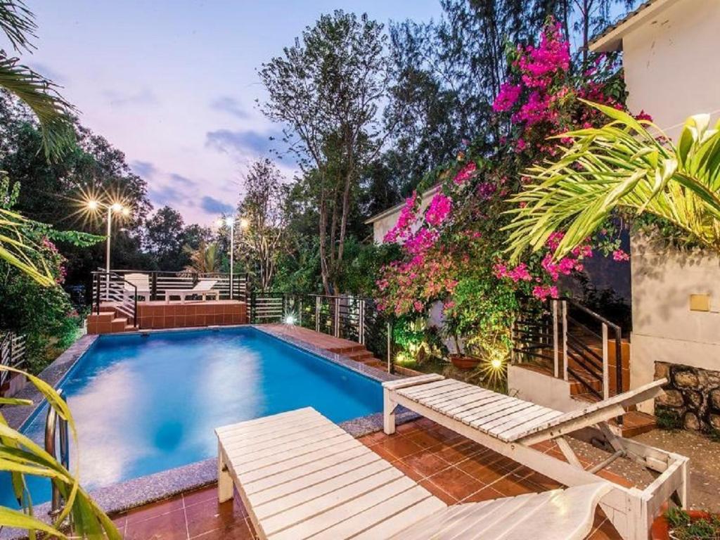 a swimming pool with a bench and some flowers at Ngoc Hanh Bungalow Phu Quoc in Phu Quoc