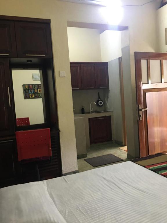 a room with a bed and a kitchen at Transit cabin in Seeduwa