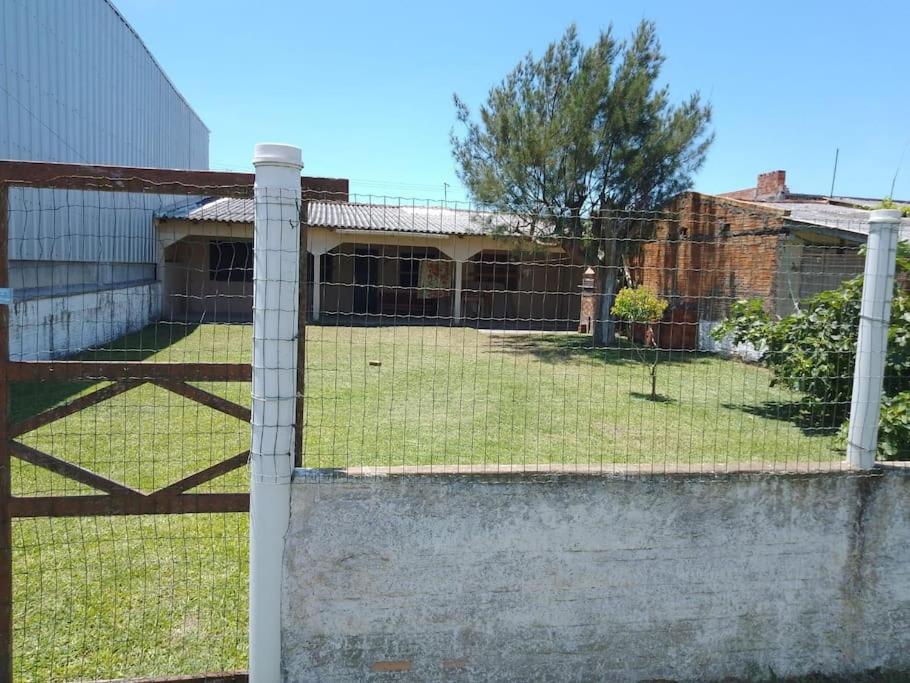 een hek met een hek in een tuin bij Casa bem localizada Cidreira in Cidreira