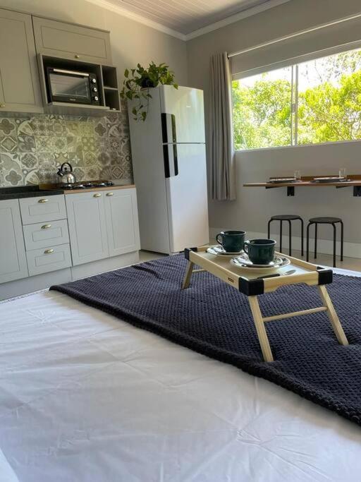 una cocina con una mesa con dos tazones. en Studio Flor do Mato, en Itapema