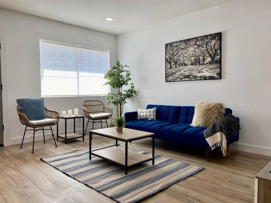 a living room with a blue couch and a table at Uniquely remodeled historical district home in Phoenix