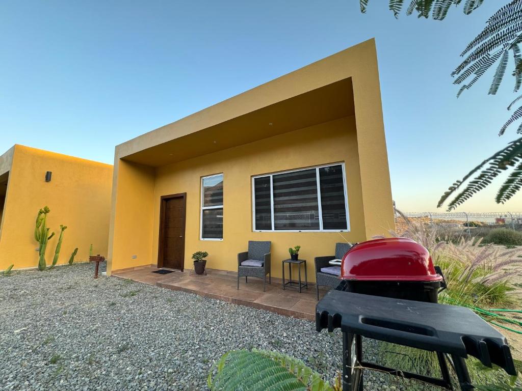 een klein geel huis met een rode grill ervoor bij Cozy & Quiet Pet friendly Studio in Ensenada