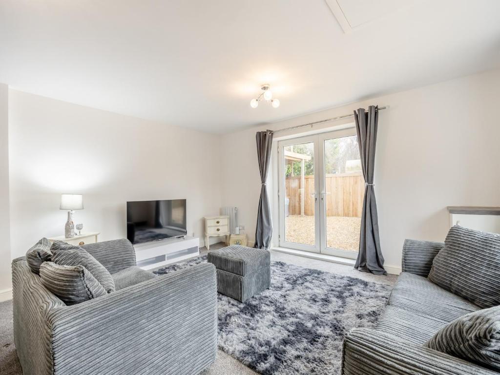 a living room with two couches and a tv at Lazy Acre in Holbeach