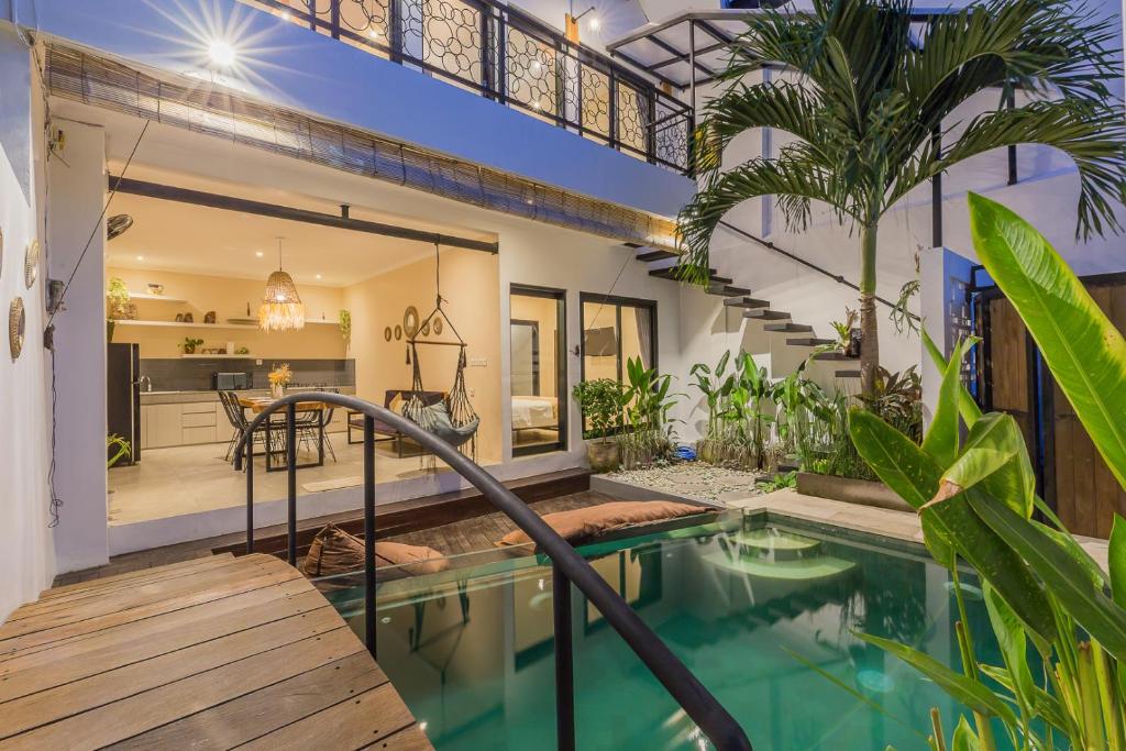 a home with a swimming pool and a house at Villas Krisna Canggu WCS in Canggu