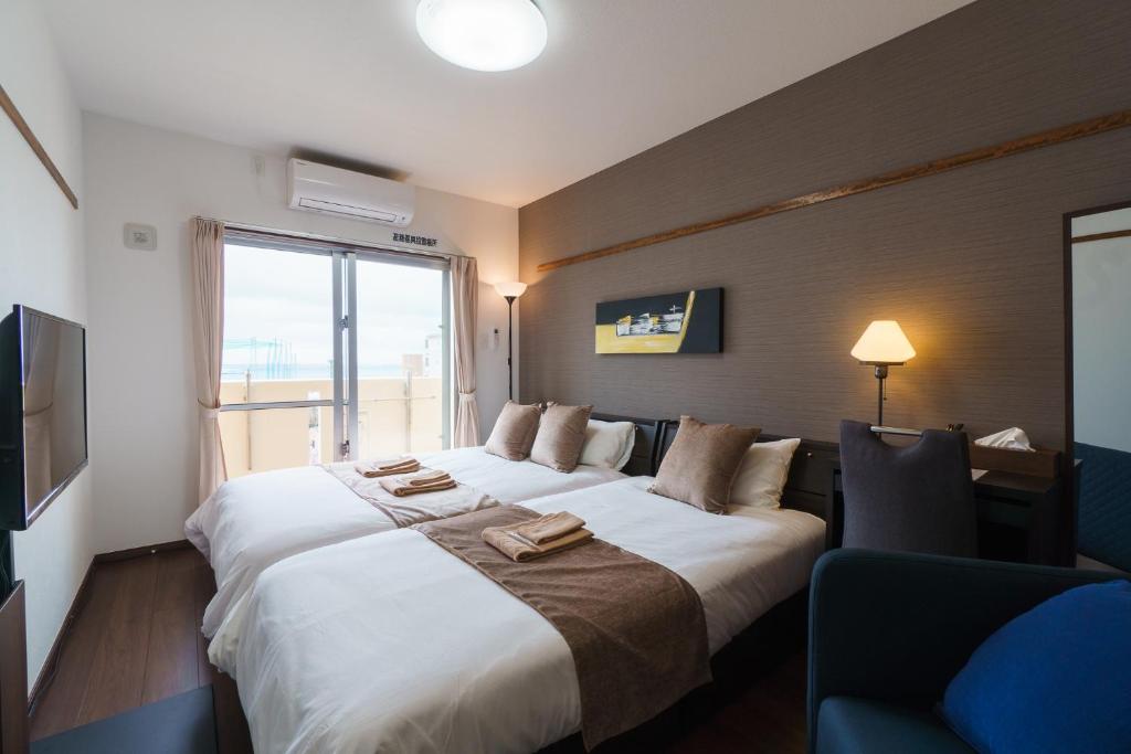 那覇市にあるKINTARO Hotel Okinawa Nahaの大きなベッドと窓が備わるホテルルームです。