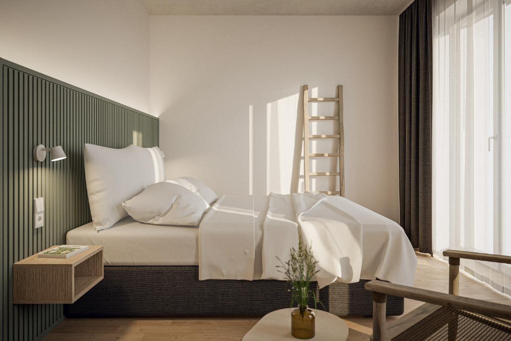 a bedroom with a bed with white sheets and a ladder at NOORD Carolinensiel in Carolinensiel