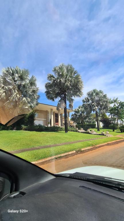 a car parked in front of a house with palm trees at Vista Bela in Aparecida de Goiania