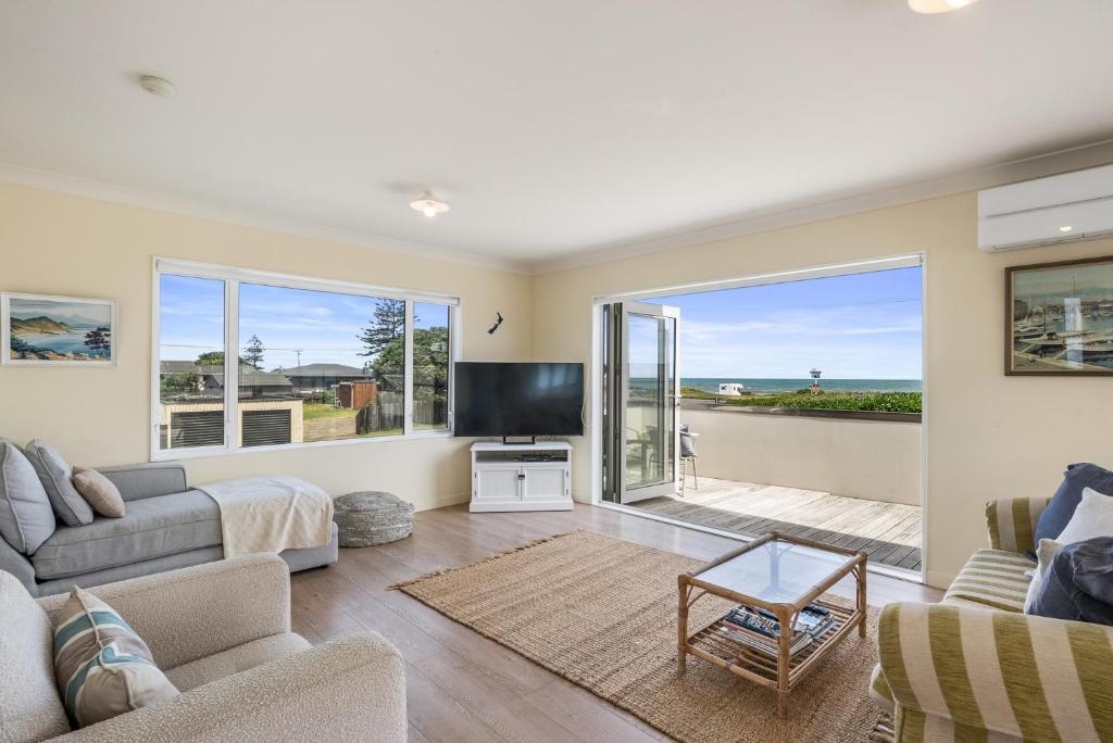 a living room with a couch and a tv at Otaki Beach Haven - Otaki Beach Holiday Unit in Otaki