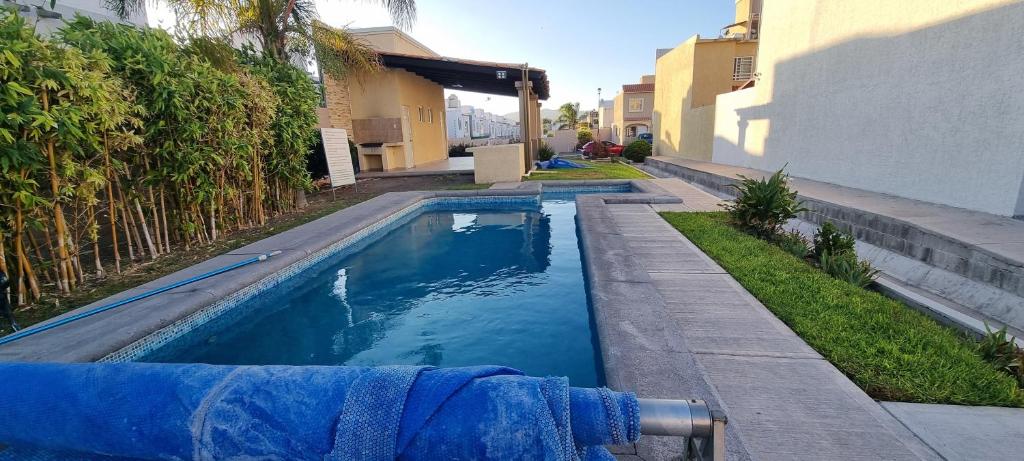 a swimming pool with blue water in a yard at Casa con Alberca Alba in Querétaro