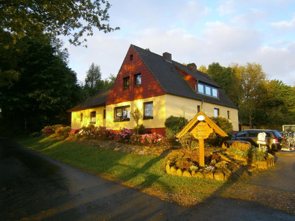 ein Haus mit einem Schild davor in der Unterkunft Pension Sander in Bispingen