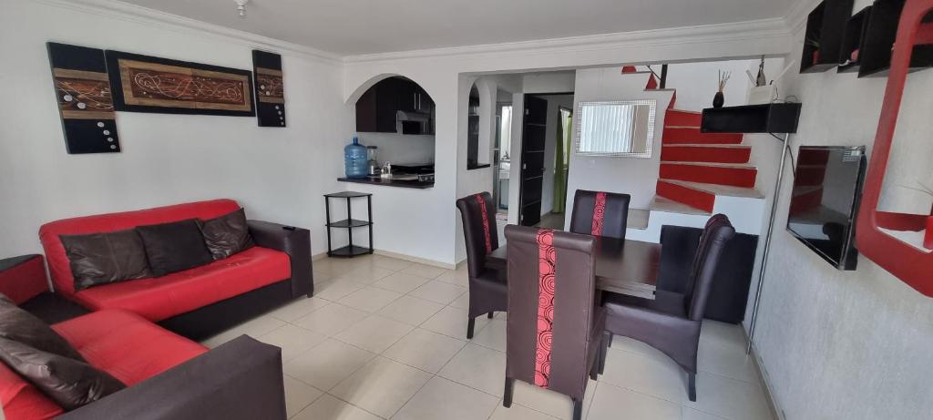a living room with a red couch and a table at Casa con alberca Lomas de San Pedro in Querétaro