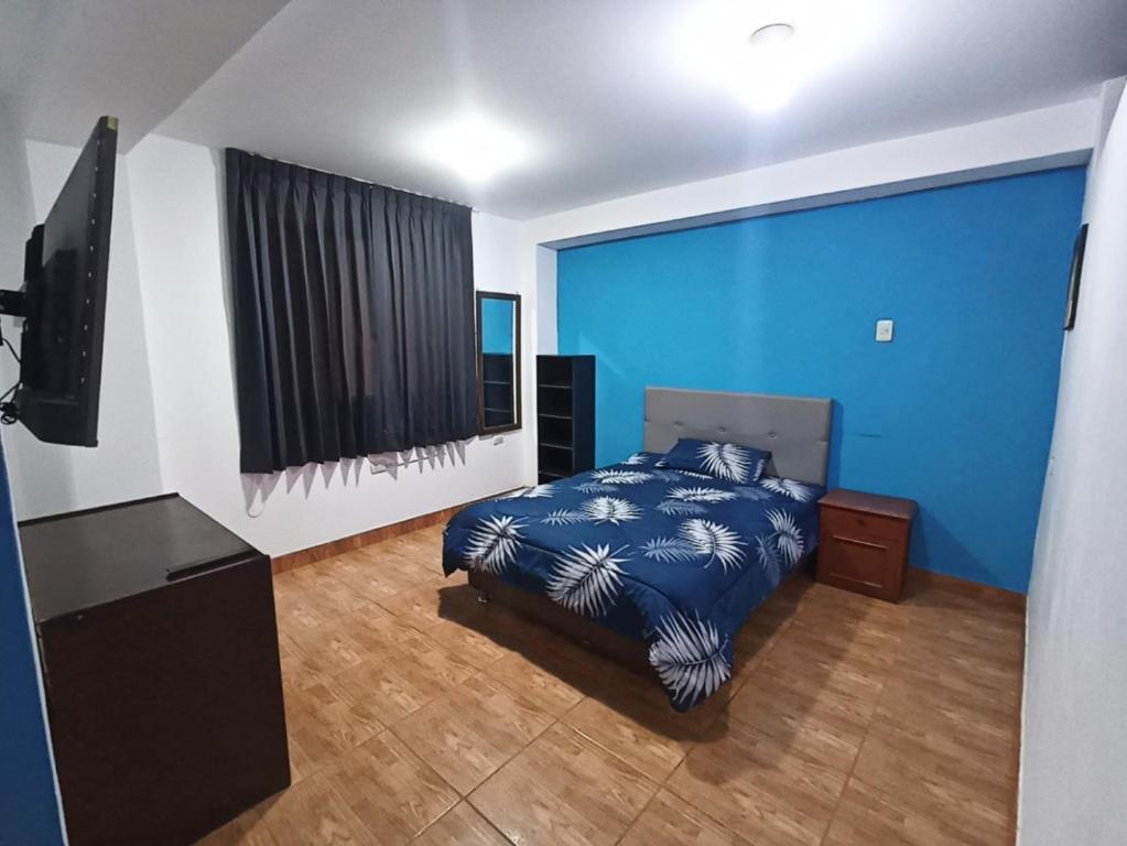 Schlafzimmer mit einem Bett und einem Flachbild-TV in der Unterkunft Habitación en Cajamarca in Cajamarca