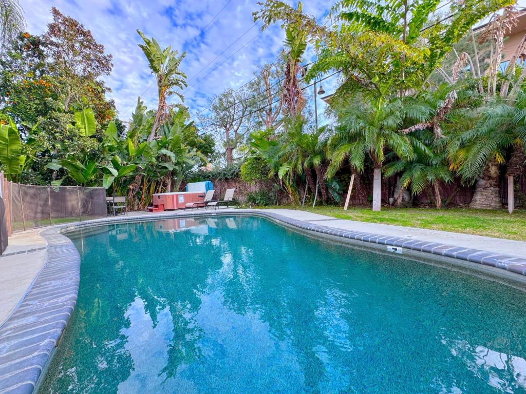 a swimming pool in a yard with palm trees at Rainforest Villa 4 Bedroom PoolSpa Walk2Disneyland in Anaheim