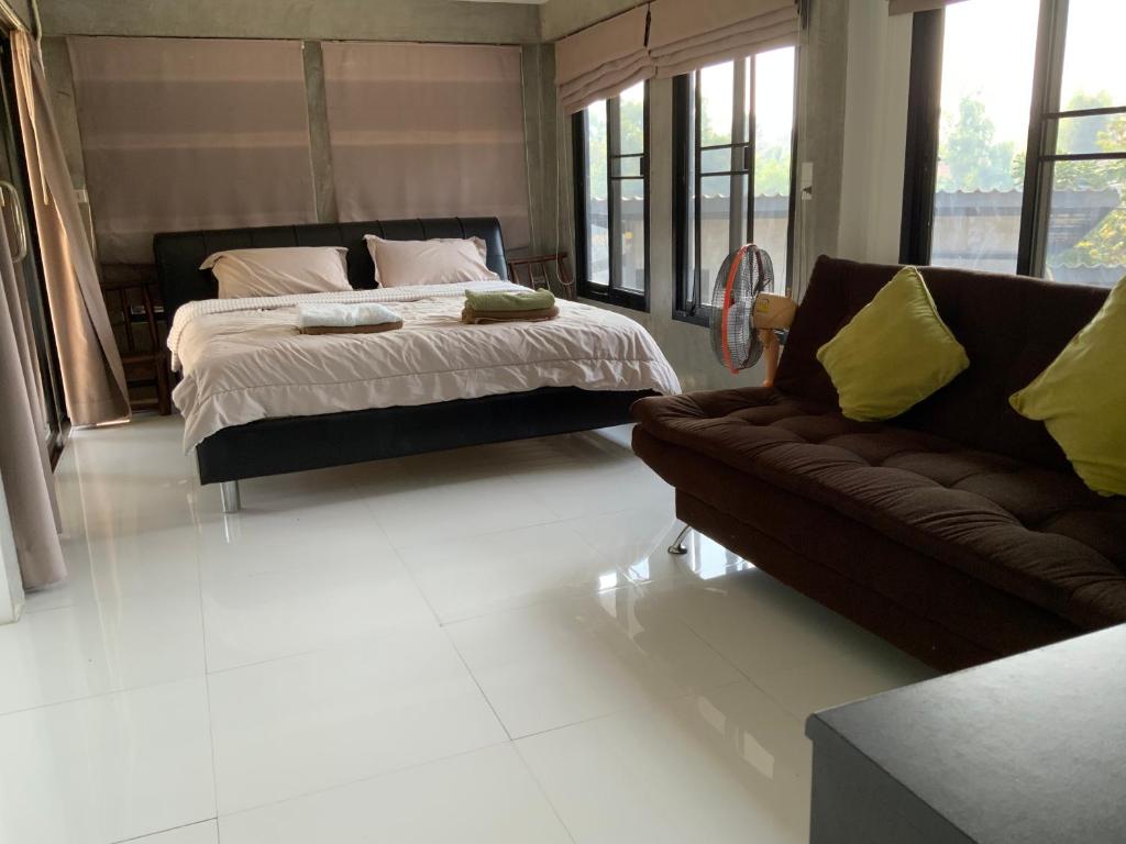 - une chambre avec un lit et un canapé dans l'établissement Morocco Blue cafe by Chilong River Farm Resort, à Muang Kosum