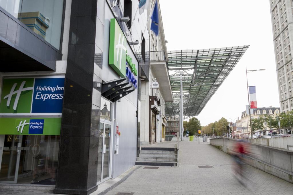 a person walks past a building in a city at Holiday Inn Express Amiens, an IHG Hotel in Amiens