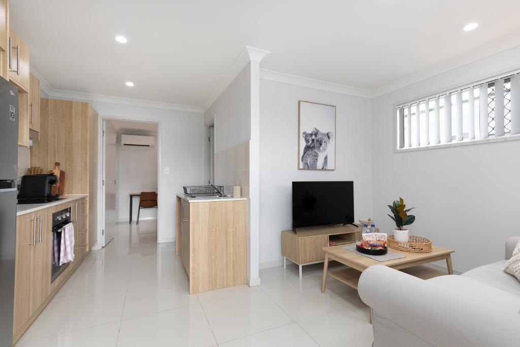 a living room with a couch and a tv at Super Host, Well Presented with Wi-Fi! in Brisbane