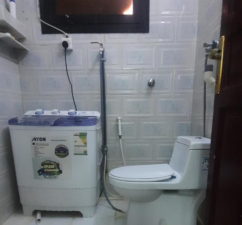 a bathroom with a toilet and a water heater at العنبرية2 in Al Madinah