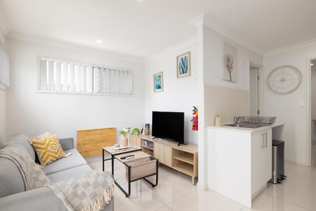 a living room with a couch and a tv at New Listing, Wi-Fi and Laundry in Brisbane