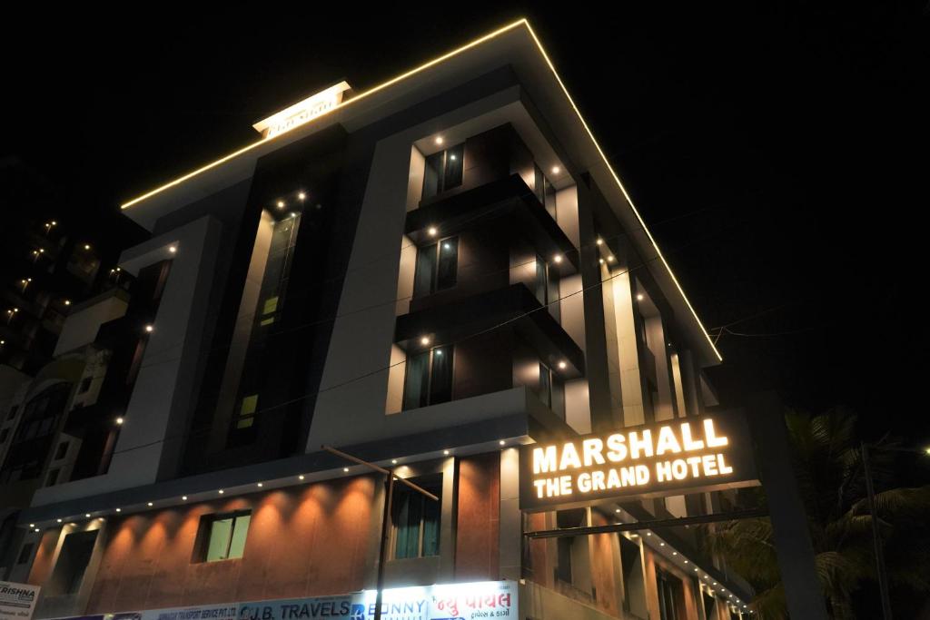 a building with a sign in front of it at night at Marshall The Grand Hotel in Ahmedabad