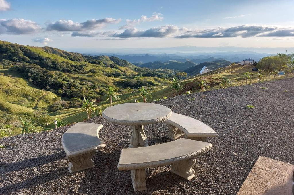 una mesa y dos sillas sentadas en la cima de una montaña en Apartamentito moderno con vista en Monteverde, en Cebadilla