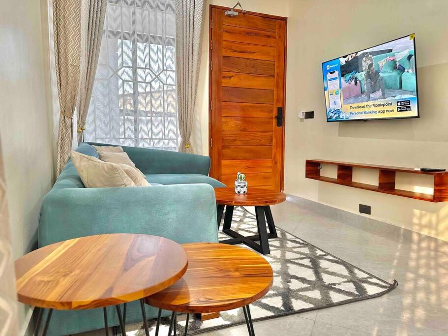 a living room with a couch and two tables at F.A.M Homes Tabata in Dar es Salaam