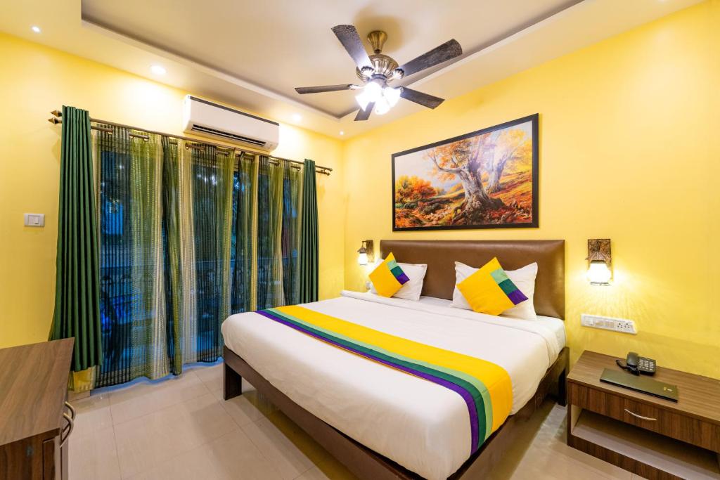 a bedroom with a large bed and a ceiling fan at Itsy By Treebo - Adams Beach Resort 350 Mtrs From Baga Beach in Baga