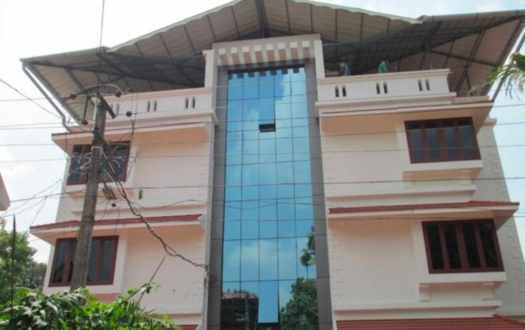 un edificio con una ventana azul a un lado. en OYO Abriz Inn, en Elūr