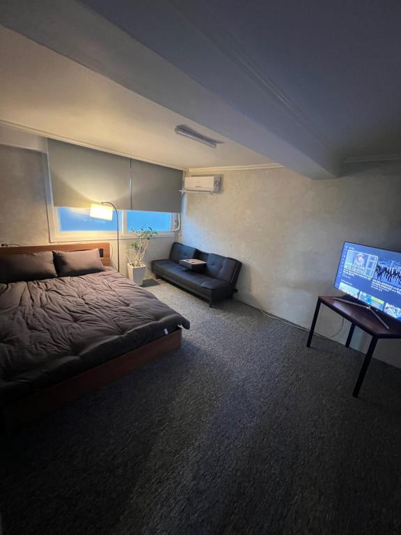 a bedroom with a bed and a flat screen tv at Apartment in Gangnam in Seoul