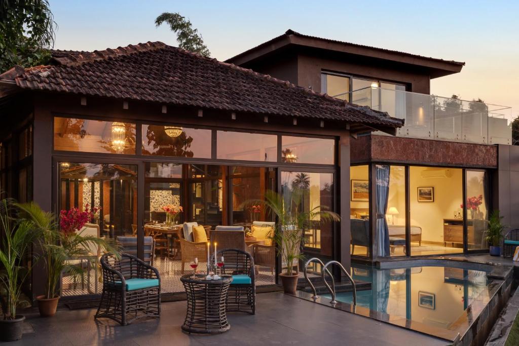 ein Haus mit Glastüren und einer Terrasse in der Unterkunft Aalia Villas Anjuna, Goa by Aalia Collection in Anjuna