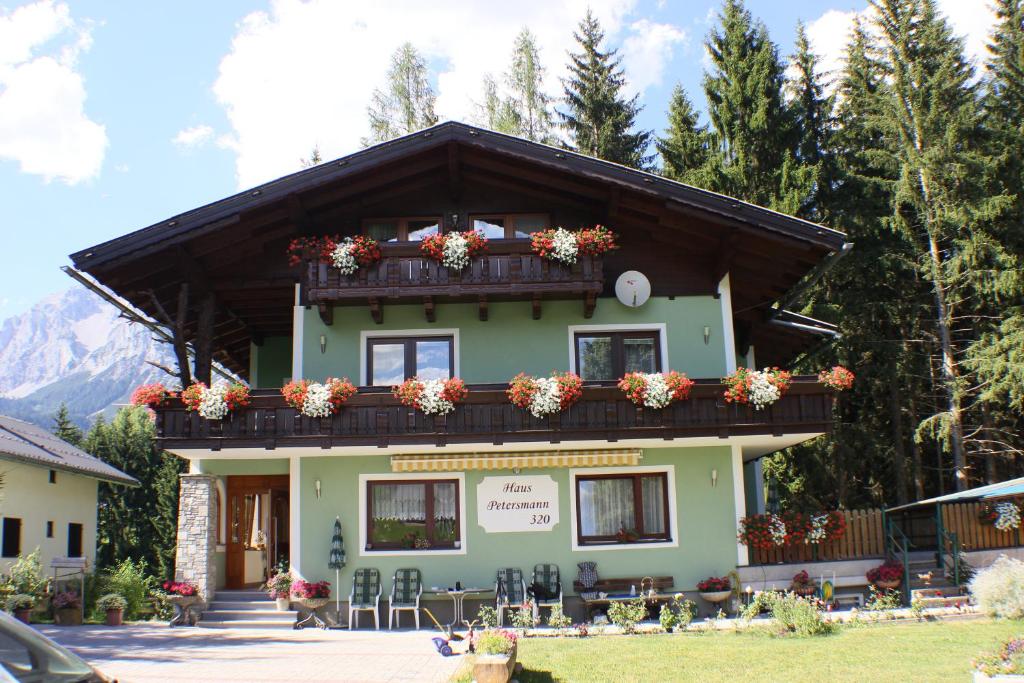 a building with a balcony with flowers on it at Haus Petersmann in Ramsau am Dachstein