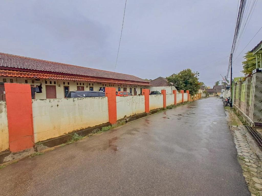 an empty street with a fence on the side at OYO 93590 Penginapan Palapa 10 Syariah in Bandar Lampung