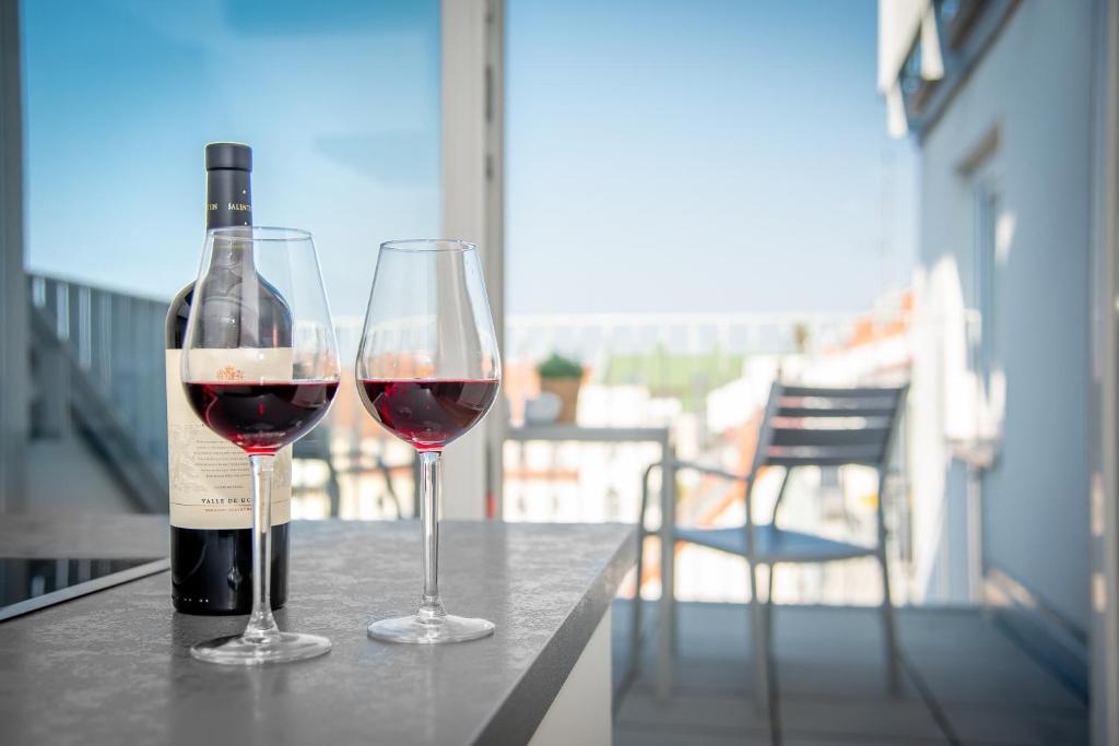 eine Flasche Wein und zwei Gläser auf dem Tisch in der Unterkunft StayS Apartments in Nürnberg