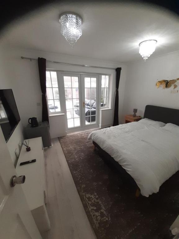 een slaapkamer met een bed en een groot raam bij Lovely and Spacious Room with Conservatory in Gravesend