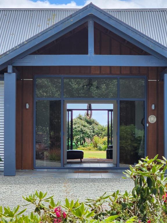 una porta a vetri aperta di una casa con un divano all'interno di Woodlands a Geraldine