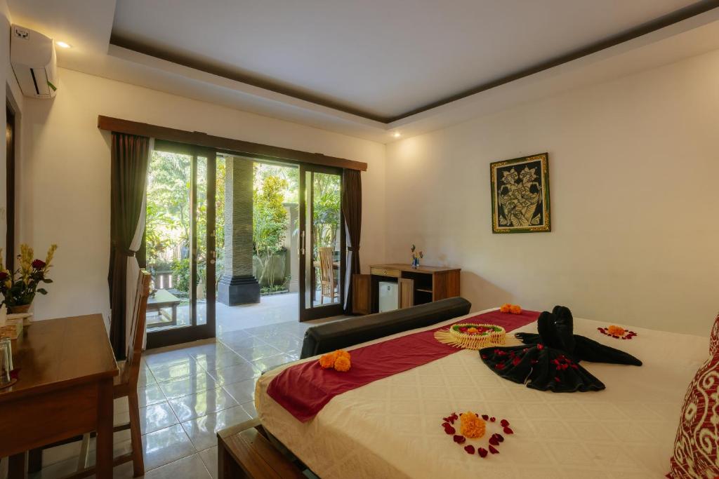 Ubud Harmony Private Villa and Pool في أوبود: غرفة نوم بسرير ومكتب ونافذة