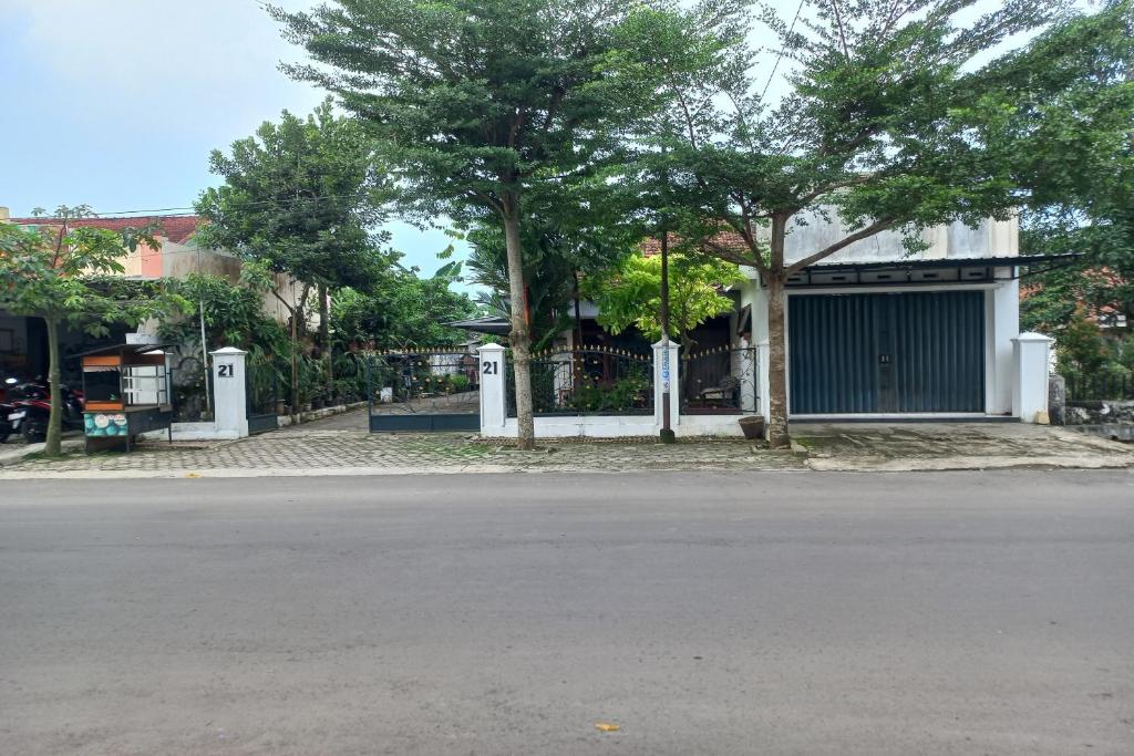 an empty street with trees and a building at SPOT ON 93606 Juan Kostel 3 in Purwokerto