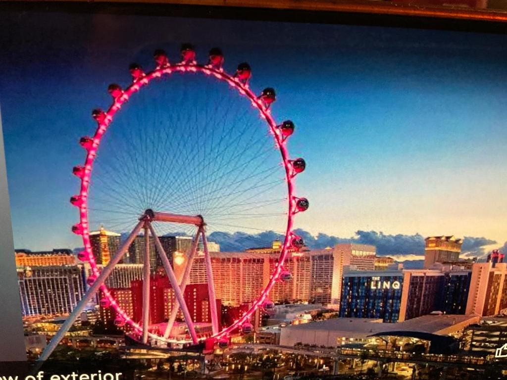 a ferris wheel in front of a city at The Linq Hotel in Las Vegas