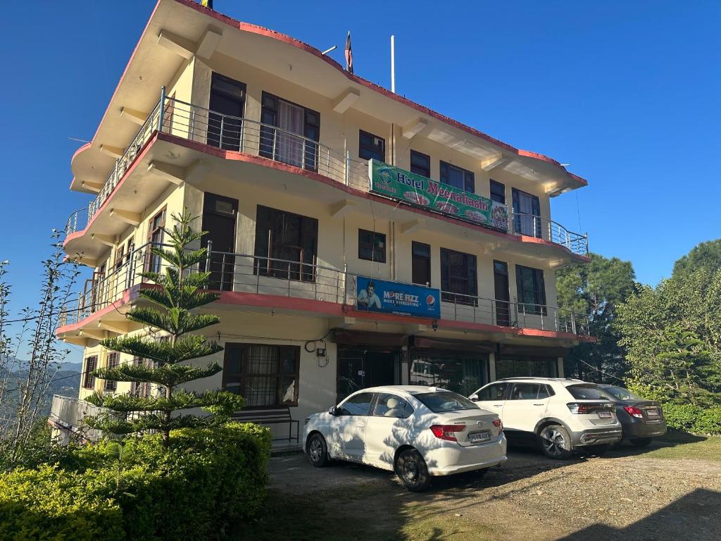 two cars parked in front of a building at Minakshi hotel and restaurant in Mandi