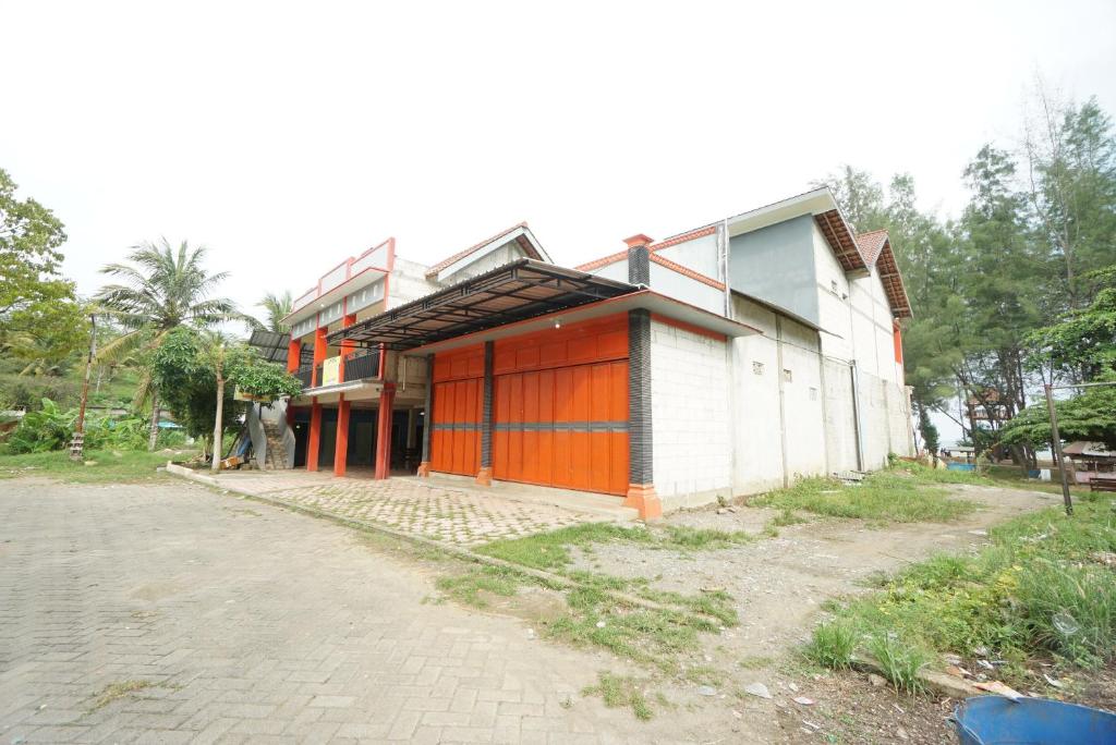 um edifício com portas cor-de-laranja ao lado em SPOT ON 93620 Anisa Homestay Syariah em Tulungagung