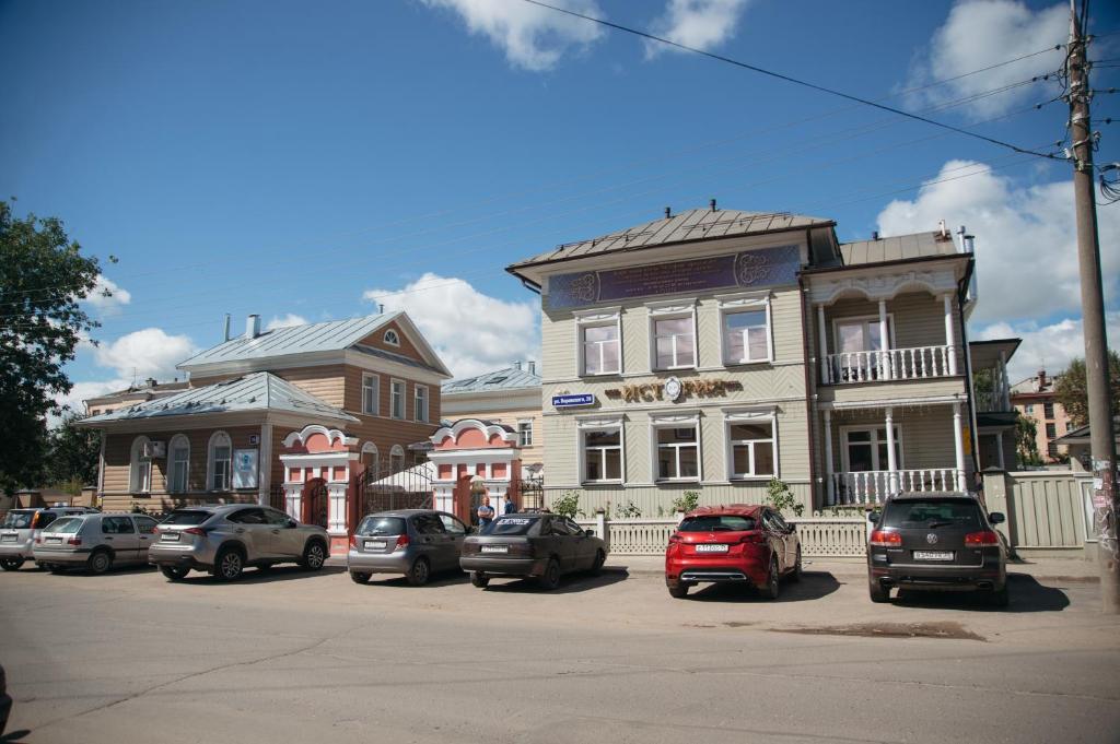 a street with cars parked in front of a building at History Hotel in Vologda