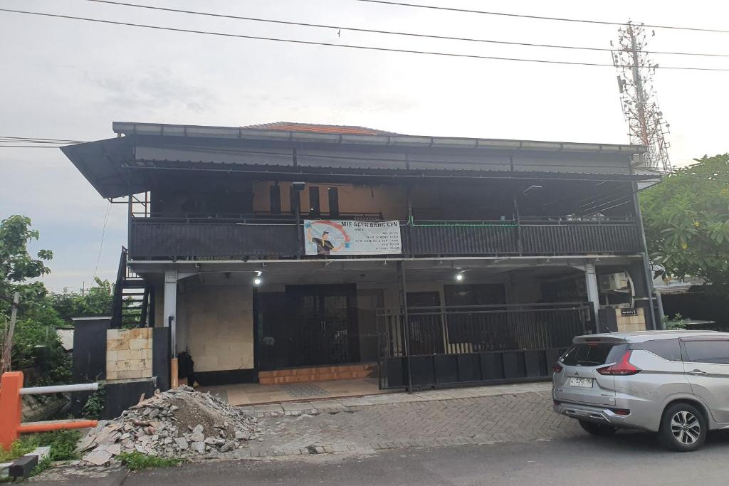 um edifício com um carro estacionado em frente em OYO 93625 Uno Homestay Syariah em Surabaya