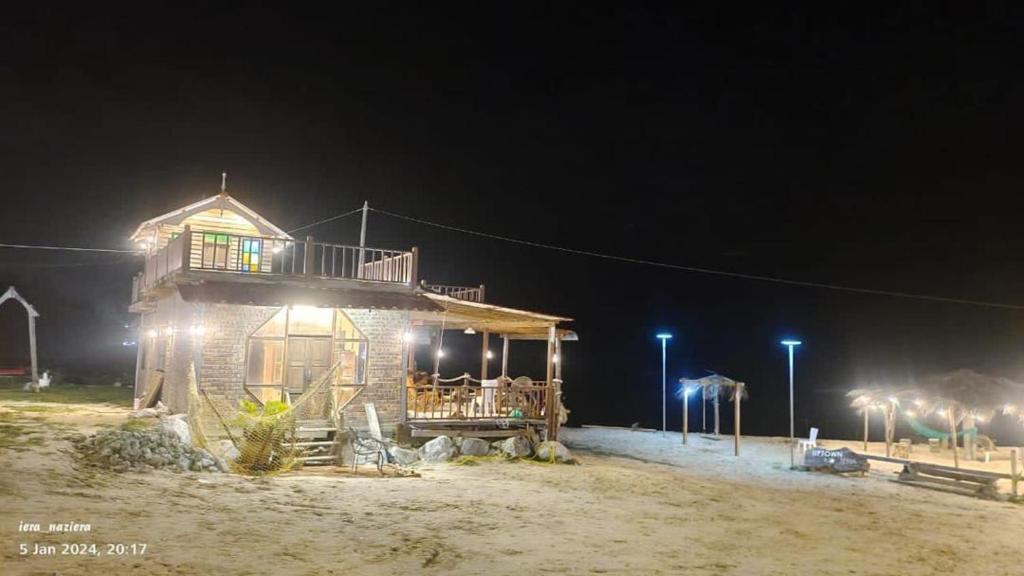 a small house with lights on a beach at night at Rumahbatu beach cottage in Kuala Terengganu