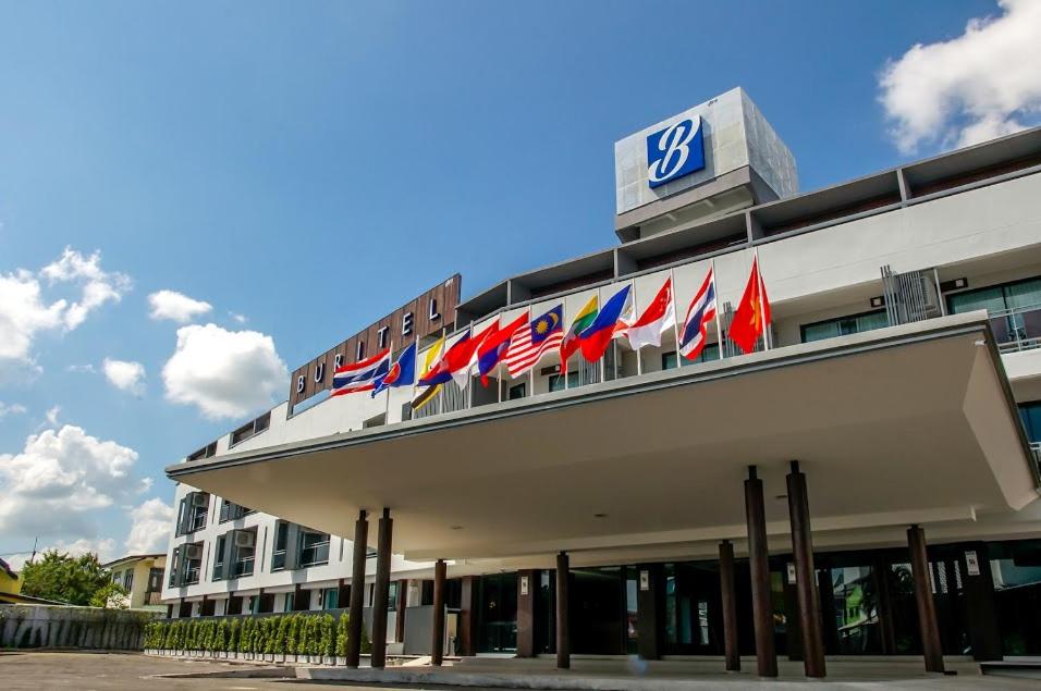 Un edificio con un montón de banderas. en Buritel Hotel en Buriram